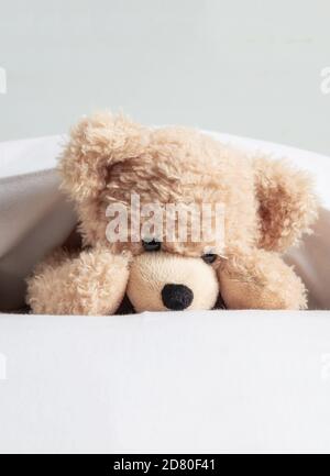 Les enfants l'heure du coucher. Cute teddy portant sur matelas lit jouant avec des oreillers Banque D'Images