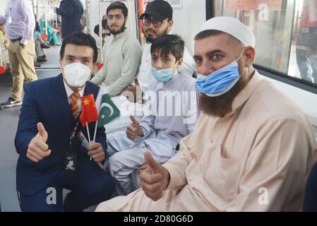 Les Pakistanais et les Chinois détenant les drapeaux nationaux des deux pays et appréciant de voyager dans le métro ligne Orange (OLMT), alors que le ministre en chef du Punjab, Sardar Usman Buzdar, inaugurait le projet de métro ligne Orange à Lahore, au Pakistan, le 24 octobre 2020. Ce projet comprend vingt-six stations et voies couvrant plus de 27,12 km. Il s'agit du premier projet de transport public à courant électrique par lequel environ deux personnes se déplacent quotidiennement dans le lac cinquante mille.un projet de métro prévu dans le cadre du corridor économique Chine-Pakistan (CPEC), passe sur une voie après son ouverture officielle dans l'eas Banque D'Images