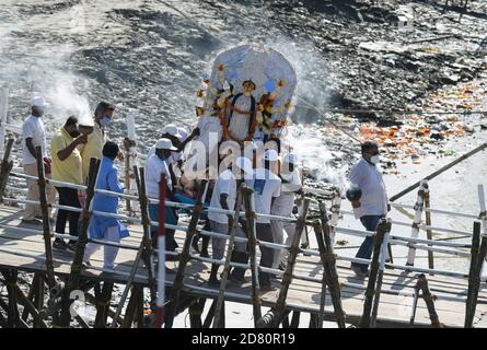 Les ouvriers municipaux portent une idole de la déesse hindoue Durga pour immersion dans les eaux de la rivière Brahmaputra pendant la dernière journée du festival Durga Puja à Guwahati, en Inde, le 26 octobre 2020. Le dernier jour du festival s'appelle Vijay Dashmi, Vijaya signifiant « victoire » et Dashmi signifiant « dixième ». Durga Puja est largement célébrée dans les États indiens du Bengale occidental, Assam, Jharkhand, Orissa et Tripura et culmine dans l'immersion des idoles de la déesse hindoue Durga, qui symbolise la puissance et le triomphe du bien sur le mal dans la mythologie hindoue. Crédit : David Talukdar/Alay Live News Banque D'Images