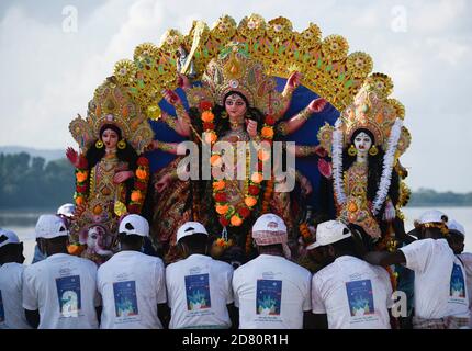 Les ouvriers municipaux portent une idole de la déesse hindoue Durga pour immersion dans les eaux de la rivière Brahmaputra pendant la dernière journée du festival Durga Puja à Guwahati, en Inde, le 26 octobre 2020. Le dernier jour du festival s'appelle Vijay Dashmi, Vijaya signifiant « victoire » et Dashmi signifiant « dixième ». Durga Puja est largement célébrée dans les États indiens du Bengale occidental, Assam, Jharkhand, Orissa et Tripura et culmine dans l'immersion des idoles de la déesse hindoue Durga, qui symbolise la puissance et le triomphe du bien sur le mal dans la mythologie hindoue. Crédit : David Talukdar/Alay Live News Banque D'Images