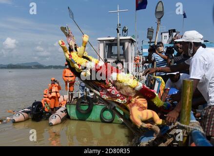 Les ouvriers municipaux portent une idole de la déesse hindoue Durga pour immersion dans les eaux de la rivière Brahmaputra pendant la dernière journée du festival Durga Puja à Guwahati, en Inde, le 26 octobre 2020. Le dernier jour du festival s'appelle Vijay Dashmi, Vijaya signifiant « victoire » et Dashmi signifiant « dixième ». Durga Puja est largement célébrée dans les États indiens du Bengale occidental, Assam, Jharkhand, Orissa et Tripura et culmine dans l'immersion des idoles de la déesse hindoue Durga, qui symbolise la puissance et le triomphe du bien sur le mal dans la mythologie hindoue. Crédit : David Talukdar/Alay Live News Banque D'Images