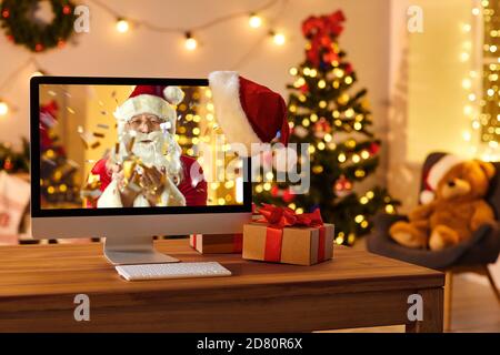 Ordinateur sur le bureau avec Santa sur écran soufflé confetti et Joyeux Noël et bonne année Banque D'Images