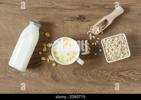 Lait de substitution non laitier fait maison à base de flocons d'avoine. Lait d'avoine végétalien sur une table en bois. Banque D'Images