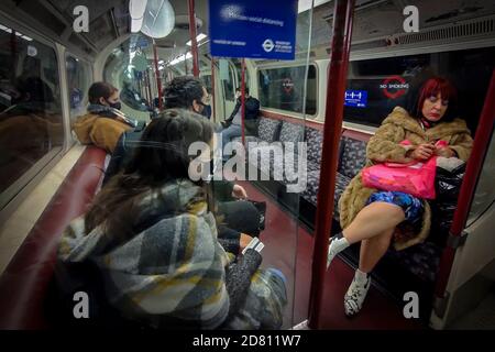 Londres, Royaume-Uni. 26 octobre 2020. Passager voyageant avec un masque porté sous le menton dans le métro de Londres. Le port de masques faciaux pour couvrir le nez et la bouche reste obligatoire pour voyager sur le tube à mesure que la pandémie du coronavirus se poursuit. Avec l'augmentation du nombre de cas de coronavirus au Royaume-Uni, la capitale est récemment passée du niveau d'alerte Covid de niveau 1 au niveau d'alerte Covid de niveau 2. Credit: Stephen Chung / Alamy Live News Banque D'Images