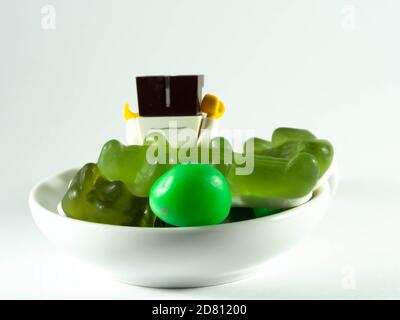 Photographier le 25 octobre 2020 en France UNE tasse remplie de bonbons verts. Un enfant cupide. Banque D'Images