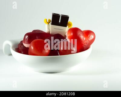 Photographier le 25 octobre 2020 en France UNE tasse remplie de bonbons rouges. Un enfant cupide. Banque D'Images