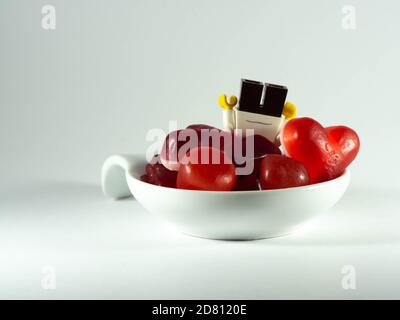 Photographier le 25 octobre 2020 en France UNE tasse remplie de bonbons rouges. Un enfant cupide. Banque D'Images