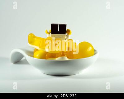 Photographier le 25 octobre 2020 en France UNE tasse remplie de bonbons jaunes. Un enfant cupide. Banque D'Images