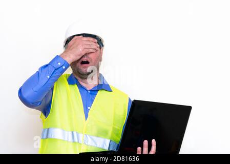 Attrayant technicien caucasien tenant l'ordinateur portable sur fond blanc.fait des gestes Banque D'Images