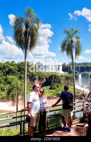 Les touristes prenant des photos d'eux-mêmes avec des palmiers et des chutes d'Iguazu, Cataratas del Iguaza. Le parc national d'Iguazu est classé au patrimoine mondial de l'UNESCO à Banque D'Images