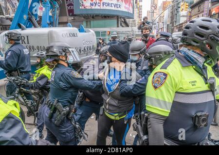 Les policiers du NYPD arrêtent un manifestant anti-Trump pour comportement désordonné durant la manifestation.les partisans du président pro-Trump défilent le long de la 5e avenue avec une caravane de voitures et un énorme drapeau bleu, blanc et noir de Trump. Ils marchent de la Trump Tower sur la 5e Avenue à la 42e rue et de là à Times Square où ils ont rencontré des contre-manifestants. Les manifestants anti-Trump ont lancé des insultes et des objets comme des bouteilles et des œufs remplis de peinture. Il y a eu beaucoup de bagarres entre ces deux groupes et la police a procédé à plus d'une douzaine d'arrestations. Banque D'Images