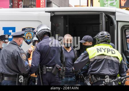 Les policiers du NYPD arrêtent un manifestant anti-Trump pour comportement désordonné durant la manifestation.les partisans du président pro-Trump défilent le long de la 5e avenue avec une caravane de voitures et un énorme drapeau bleu, blanc et noir de Trump. Ils marchent de la Trump Tower sur la 5e Avenue à la 42e rue et de là à Times Square où ils ont rencontré des contre-manifestants. Les manifestants anti-Trump ont lancé des insultes et des objets comme des bouteilles et des œufs remplis de peinture. Il y a eu beaucoup de bagarres entre ces deux groupes et la police a procédé à plus d'une douzaine d'arrestations. Banque D'Images