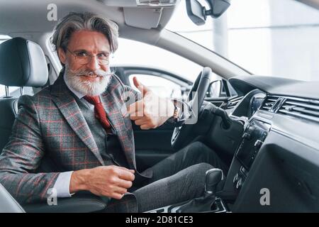 Joyeux homme âgé élégant avec des cheveux gris et une moustache pouce vers le haut Banque D'Images