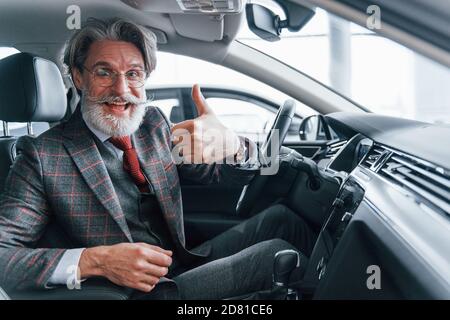 Joyeux homme âgé élégant avec des cheveux gris et une moustache pouce vers le haut Banque D'Images