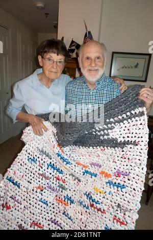 Un couple âgé vivant dans un centre communautaire présente un tapis artistique qu'elle a tiré d'un assortiment de sacs en plastique. Downers Grove Illinois, Illinois, États-Unis Banque D'Images