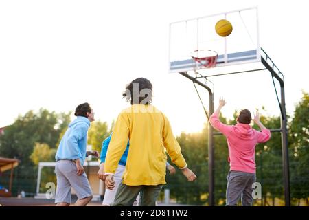 slam dunk. jeunes joueurs de basket-ball caucasiens, les garçons lancent du ballon dans le panier de basket-ball sur le terrain de jeu. les jours d'été, les vacances Banque D'Images