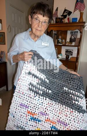 La femme âgée qui vit dans une maison de retraite affiche fièrement un tapis tissé fait de sacs de shopping en plastique. Downers Grove Illinois, Illinois, États-Unis Banque D'Images