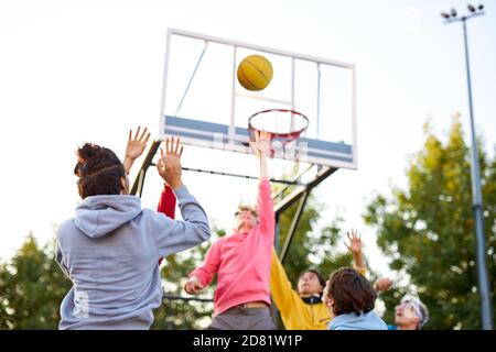 slam dunk. jeunes joueurs de basket-ball caucasiens, les garçons lancent du ballon dans le panier de basket-ball sur le terrain de jeu. les jours d'été, les vacances Banque D'Images