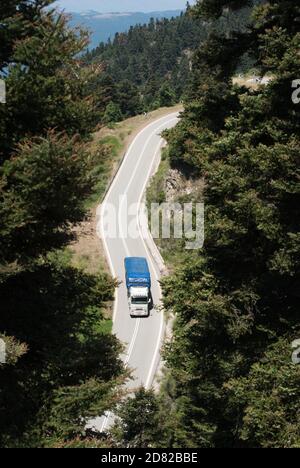 Vue aérienne d'un camion traversant une forêt d'une route de montagne en Grèce Banque D'Images