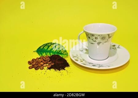 Café traditionnel et turc. Haricots torréfiés et finement moulus. Cafetière turque, plat et feuille verte. Arrière-plan isolé. Banque D'Images