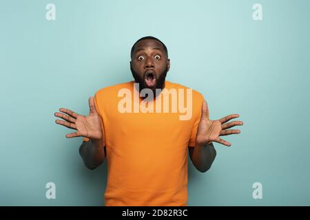 Surpris et choqué expression d'un garçon sur fond cyan Banque D'Images