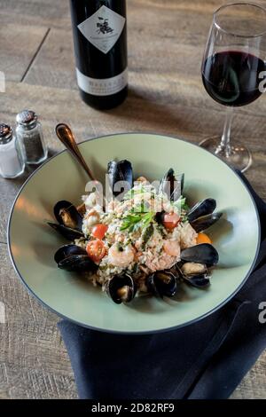 Risotto aux fruits de mer servi avec des moules, des crevettes et du vin Banque D'Images