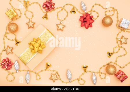 boîte cadeau ou boîte cadeau avec étoile dorée, cloche et boule sur fond doré pour les anniversaires, fêtes de noël ou cérémonies de mariage Banque D'Images