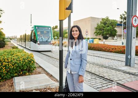 Femme attendant le métro. Elle est à l'extérieur à un arrêt de métro dans la ville. Banque D'Images