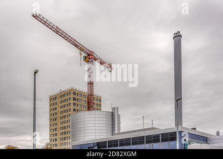 Construction de blocs d'appartements derrière une cheminée de centrale de chauffage avec une grue rouge de construction, Frederikssssssund, Danemark, 25 octobre 2020 Banque D'Images
