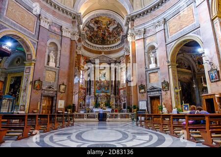 Personnes à l'église, intérieur de l'église San Giacomo in Augusta, fresques au plafond, voûte et retable, Rome, Italie. Banque D'Images