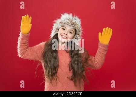 joyeux enfant dans des vêtements chauds d'hiver en tricot et des gants avec chapeau à rabats prêt pour les activités de vacances, l'hiver. Banque D'Images