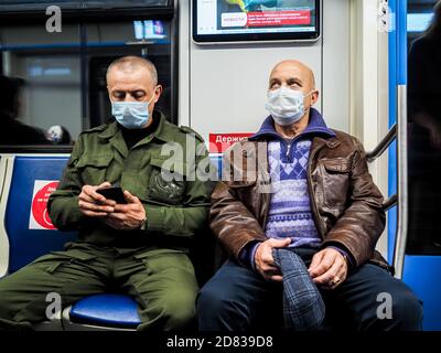 Moscou. Russie. 13 octobre 2020. Deux hommes sont assis sur un siège dans une voiture de métro. Sur le visage des passagers sont des masques de protection. Inscriptions dans Banque D'Images