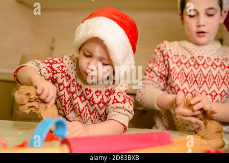 Les enfants font des biscuits pour le père Noël dans la cuisine. Cuisson maison Banque D'Images