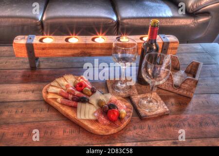 Vin rouge avec Charcuterie sur bois rustique avec bougies derrière une étendue de prosciutto panino, fromage mozzarella, salami de Gênes, fromage Fontina et Banque D'Images
