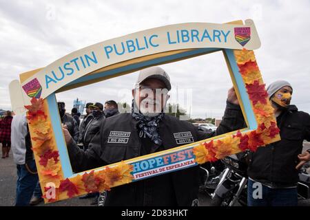 Donald Perdue, directeur du club de moto moins des Saints, possède un cadre photo de la bibliothèque publique d'Austin lors du 15e HopeFest annuel, considéré comme la plus grande foire communautaire de ressources familiales d'Austin. L'événement de cette année, parrainé par Austin Voices, a attiré des centaines de familles et des dizaines de vendeurs dans un format de passage en voiture sûr. Banque D'Images