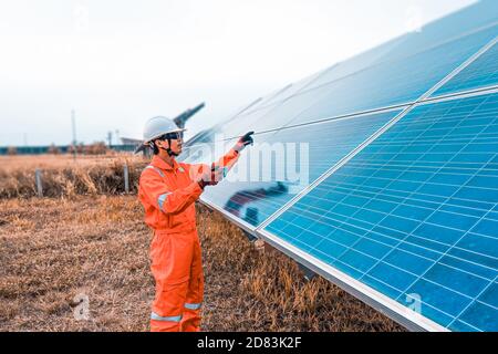 La ferme solaire (panneau solaire) avec des ingénieurs vérifie le fonctionnement du système par ordinateur portable, énergie alternative pour économiser l'énergie du monde, photo Banque D'Images