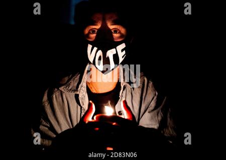 Une femme portant un masque de lecture "vote" tient une bougie tandis que les amateurs de bourre se réunissent sur les marches de la Cour suprême après le décès de la juge de la Cour suprême des États-Unis Ruth Bader Ginsburg, à Washington, DC, le 18 septembre 2020. - l'icône progressive et doyenne de la Cour suprême des États-Unis, Ruth Bader Ginsburg, est morte à l'âge de 87 ans après une bataille contre le cancer du pancréas, a annoncé le tribunal le 18 septembre 2020 crédit: Alex Edelman/The photo Access Banque D'Images