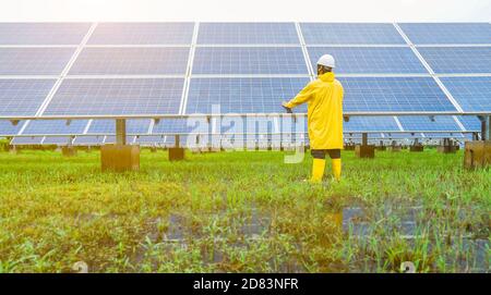 La ferme solaire (panneau solaire) avec des ingénieurs vérifie le fonctionnement du système par ordinateur portable, énergie alternative pour économiser l'énergie du monde, photo Banque D'Images