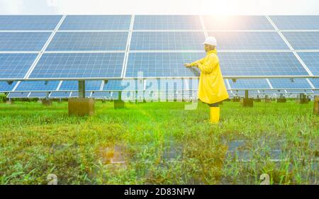 La ferme solaire (panneau solaire) avec des ingénieurs vérifie le fonctionnement du système par ordinateur portable, énergie alternative pour économiser l'énergie du monde. Banque D'Images