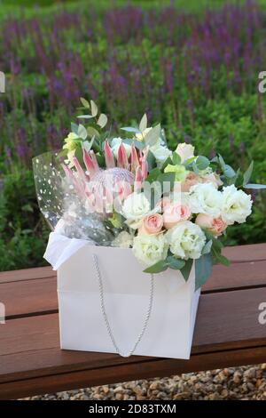 Beau bouquet de mariage dans le parc sur le banc Banque D'Images