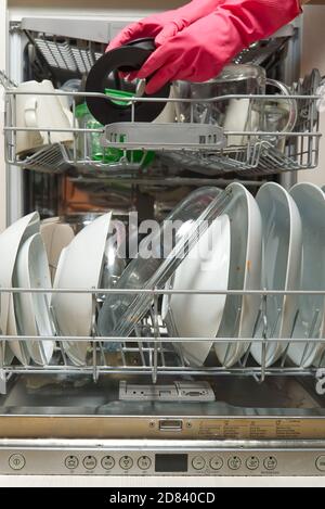 Vaisselle sale dans un lave-vaisselle ouvert intégré. Ouvrez le lave-vaisselle avec les plats sales à l'intérieur avant de le laver. Le lave-vaisselle chargé est prêt à être lavé. Banque D'Images