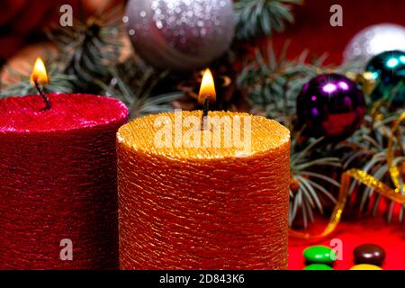 Une belle image de Noël - une bougie brûlante de couleur or sur le fond de l'arbre de Noël. Photo romantique de vacances avec bokeh Banque D'Images