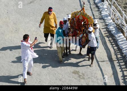 Guwahati, Assam, Inde. 26 octobre 2020. Les ouvriers municipaux portent une idole de la déesse hindoue Durga pour immersion dans les eaux de la rivière Brahmaputra pendant la dernière journée du festival Durga Puja à Guwahati, en Inde, le 26 octobre 2020. Le dernier jour du festival s'appelle Vijay Dashmi, Vijaya signifiant « victoire » et Dashmi signifiant « dixième ». Durga Puja est largement célébrée dans les États indiens du Bengale occidental, Assam, Jharkhand, Orissa et Tripura et culmine dans l'immersion des idoles de la déesse hindoue Durga. Crédit : ZUMA Press, Inc./Alay Live News Banque D'Images