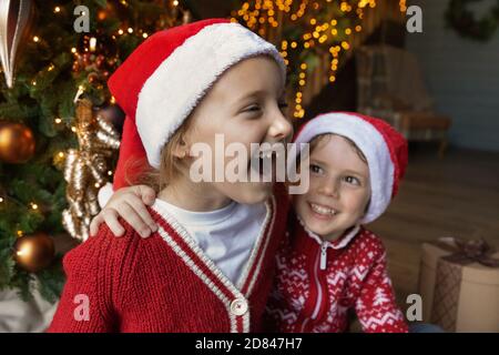 Les petits enfants excités fêtent Noël dans une maison confortable Banque D'Images