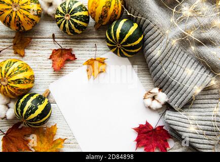 Feuilles d'érable d'automne, citrouilles et écharpe en laine sur fond de bois. Arrière-plan de l'automne. Banque D'Images
