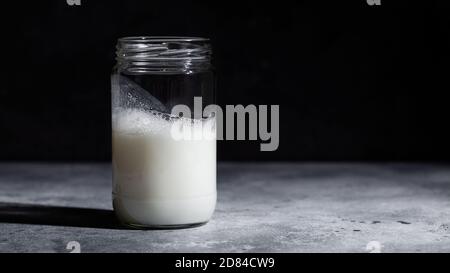 Ayran – yogourt turc mousseux dans un pot en verre sur fond sombre. Boisson probiotique saine Banque D'Images
