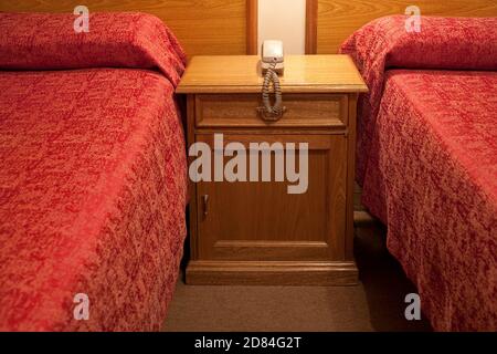 Téléphone sur une table de nuit dans une chambre d'hôtel bon marché à Buenos Aires, Argentine Banque D'Images