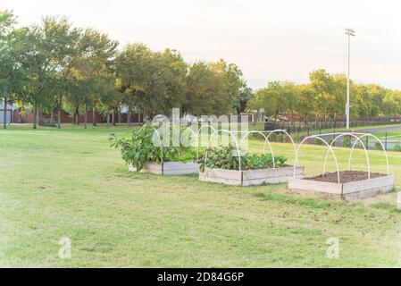 Jardin de lit surélevé avec tuyau en PVC, support de cadre froid et Pistes de course en arrière-plan à l'école primaire aux États-Unis Banque D'Images
