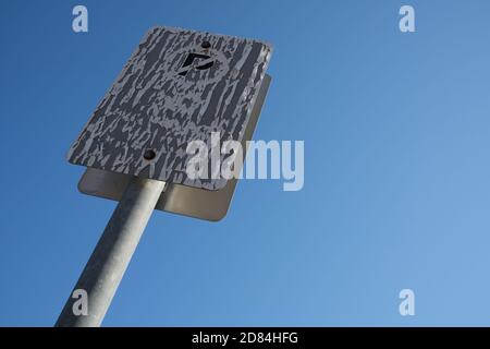 Soleil chaud endommagé pas de signe de stationnement contre un ciel bleu clair. Banque D'Images
