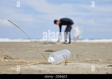 Homme nettoyant la plage des ordures Banque D'Images